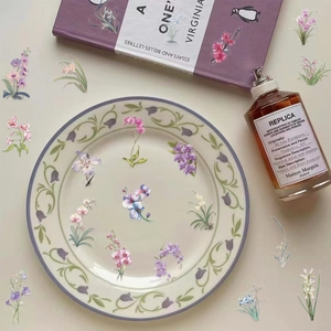 Detailed view of floral PET stickers on a vintage porcelain plate and literary book