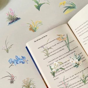 Detailed view of transparent orchid PET stickers used for decorating open book pages creatively