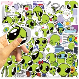 Hand holding one of 52 waterproof green alien cartoon stickers for DIY laptop decor