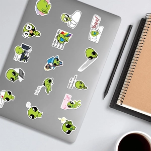 Green alien cartoon stickers with funny quotes applied on a laptop lid for decoration