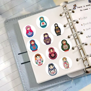 Detail of 10 colorful Russian Matryoshka doll stickers applied on a paper notebook page