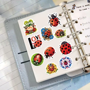 Detail view of nine cartoon ladybug and gnome decorative stickers on a notebook
