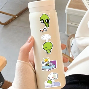 Close-up of stickers on a cream vacuum flask being held in a cozy home setting