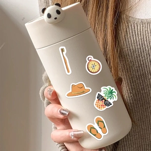 Close-up of a cream-colored panda thermal cup with cute cartoon stickers and 3D panda lid