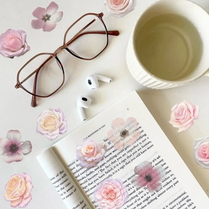 Close-up of retro brown square glasses with amber resin frames on a desk with flowers