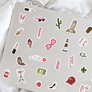 Detail of colorful waterproof DIY stickers featuring travel icons on a laptop surface