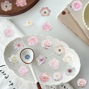 Close-up of realistic pink floral PET stickers on a decorative ceramic plate