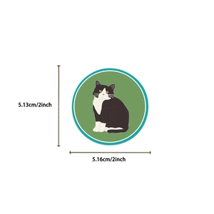 Detail shot of a 2-inch cartoon cat sticker featuring a black and white tuxedo cat illustration