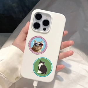 White phone case with cute vintage cat illustrations held against a fabric backdrop