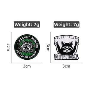 Close-up of enamel raccoon pins with funny motivational quotes on white background