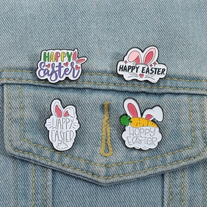 Vier bunte Oster-Emaille-Pins mit Hasenohren und Karotten auf Denim-Hintergrund