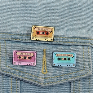 Set of retro colorful cassette enamel pins with Chill Out and Sad Vibes text on denim