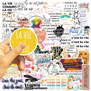 Close-up of inspirational French quote sticker featuring 'La Vie est Belle' in yellow circle