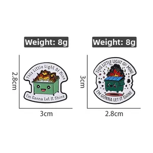 Detail view of dumpster fire enamel pins with dimensions and weight measurements