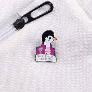 Detail of creative enamel pigeon brooch in purple suit pinned on white textured fabric