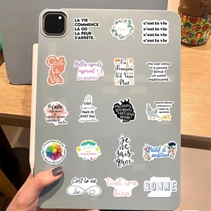 Detail showing French motivational stickers applied on the back of a tablet device