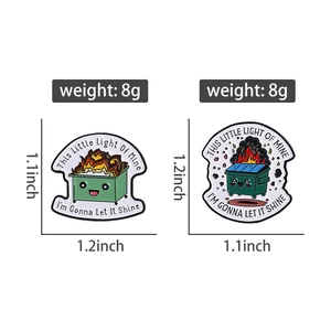 Detail view of dumpster fire enamel pins with dimensions and humorous quotes