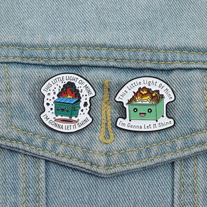 Creative cartoon dumpster fire enamel pins set on denim jacket with motivational phrases