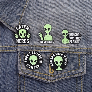 5-piece set of cartoon green alien enamel pins styled on a classic blue denim jacket