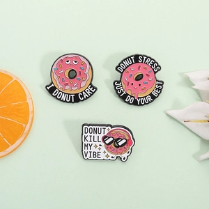 Tre spille creative in smalto a forma di ciambella rosa con citazioni su sfondo verde