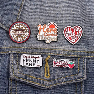 Five Beatles-themed music enamel pins on a denim jacket pocket set of 5 badges