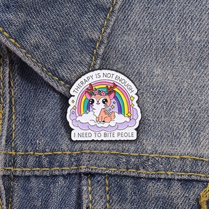 Cartoon enamel deer brooch with funny quote on a blue denim jacket background