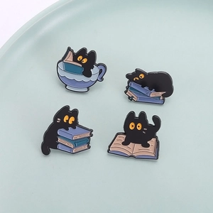 Set of 4 black cat enamel pins featuring kittens with books and teacups on a tray