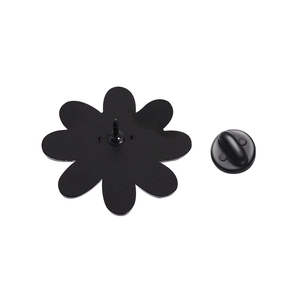 Macro detail of the metal flower brooch back featuring a rubber butterfly clutch pin