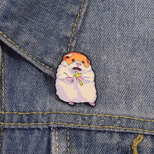 Cute hamster enamel pin holding a yellow cross badge on denim fabric background