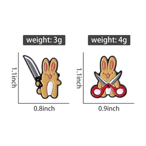 Detailed view of yellow bunny enamel pins with knife and scissors motifs and dimensions