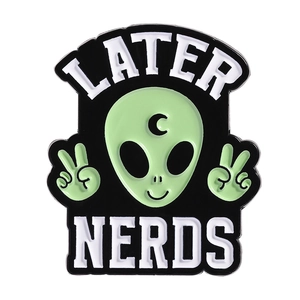 Green alien enamel pin with LATER NERDS text and peace signs on a white background