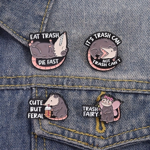 Set of four cute cartoon opossum enamel pins styled on a blue denim jacket background