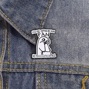 Detail of funny Flork enamel pin with Spanish text on denim jacket pocket