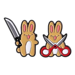Pair of creative cartoon rabbit enamel pins with knife and scissors on white background