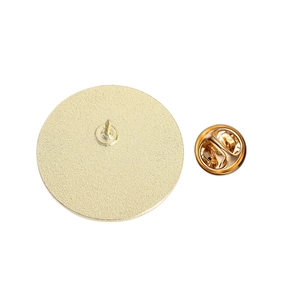 Detailed close-up of golden metal badge back with textured finish and butterfly clutch pin