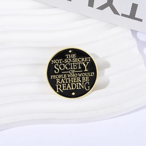 Minimalist black and gold circular enamel pin with motivational reading quote for book lovers