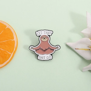 Cute meditation sloth enamel pin with Let That Shit Go quote and floral decor
