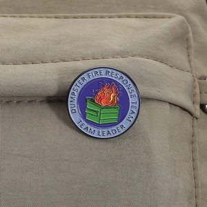 Close-up of Dumpster Fire Response Team enamel pin on khaki nylon fabric bag