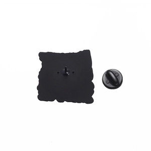 Macro view of the black metal pin back with a butterfly clutch on a matte square base