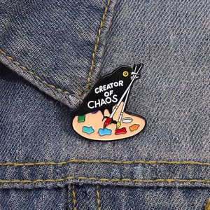 Cartoon Rabe Maler Emaille-Anstecknadel mit Palette und Creator of Chaos Text