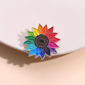 Gros plan d'une broche tournesol arc-en-ciel en émail avec un centre à pois