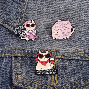 Three cartoon cat enamel pins set with sunglasses and house designs on denim fabric