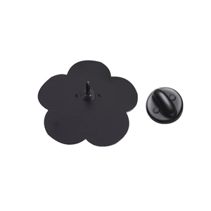 Detail of flower-shaped enamel pin back with secure black rubber clutch on white background