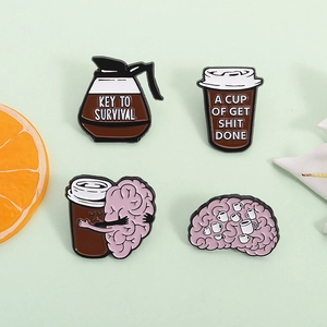 Creative coffee survival enamel pin set featuring brain and cup designs on green background