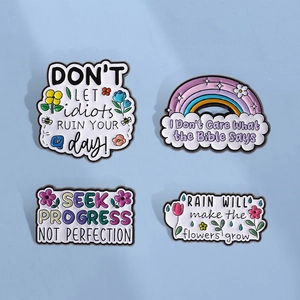 Lot de quatre pins en émail colorés avec arc-en-ciel, fleurs et citations inspirantes