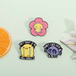 Cute enamel pins set with flower, duck, and raccoon designs on a soft green background