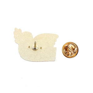 Detail view of the golden metal badge back featuring butterfly clasp and textured finish