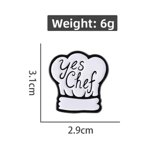 Close-up of white enamel chef hat brooch with 'yes Chef' text and size dimensions