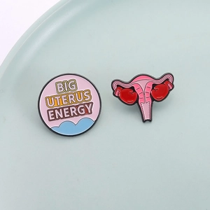 Emaille-Pin-Set für Frauenpower mit Big Uterus Energy Schriftzug und Boxhandschuh-Motiv