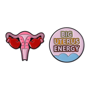 Cartoon organ enamel pins featuring Big Uterus Energy design and boxing glove motif